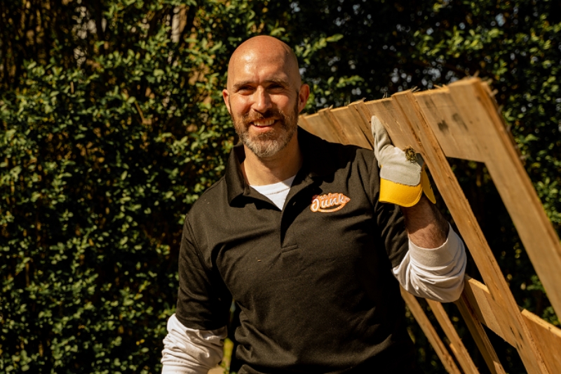 a man lifting a wood that is included to their junk removal service in we love junk
