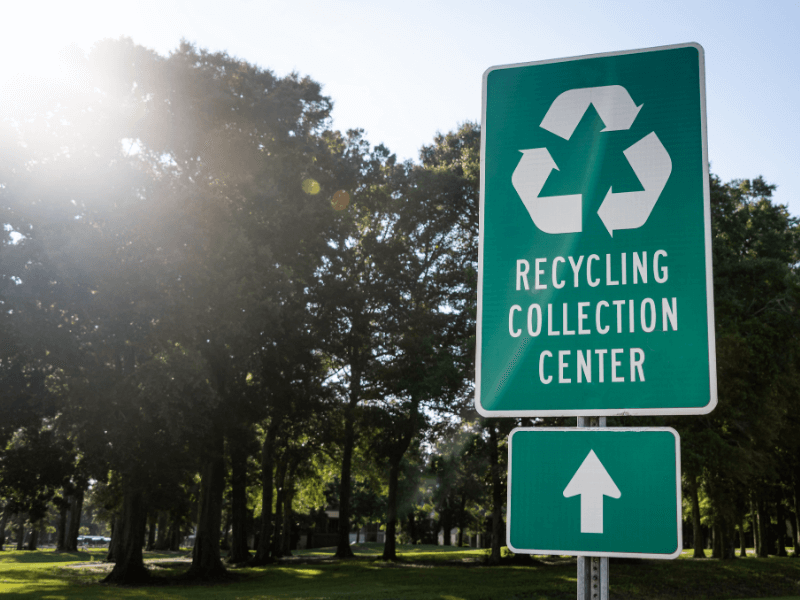Recycling collection center sign with arrow pointing forward