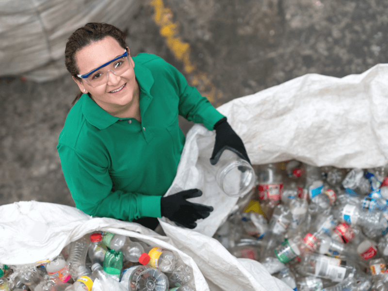 Woman sorting plastic bottles for recycling during a junk cleanout