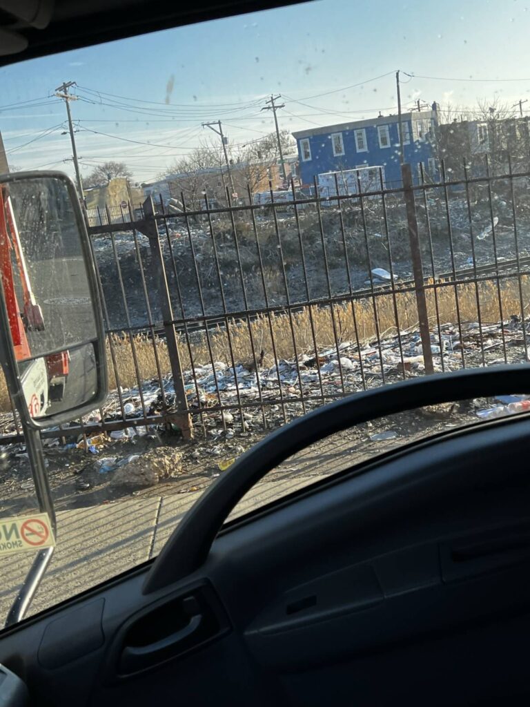 Trash and abandoned furniture in vacant urban lot